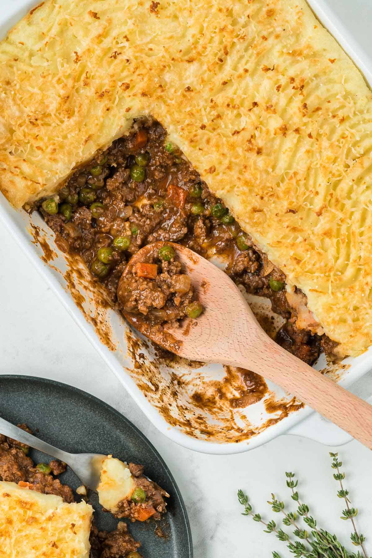 A white baking dish containing Guinness shepherd's pie with two slices taken out.