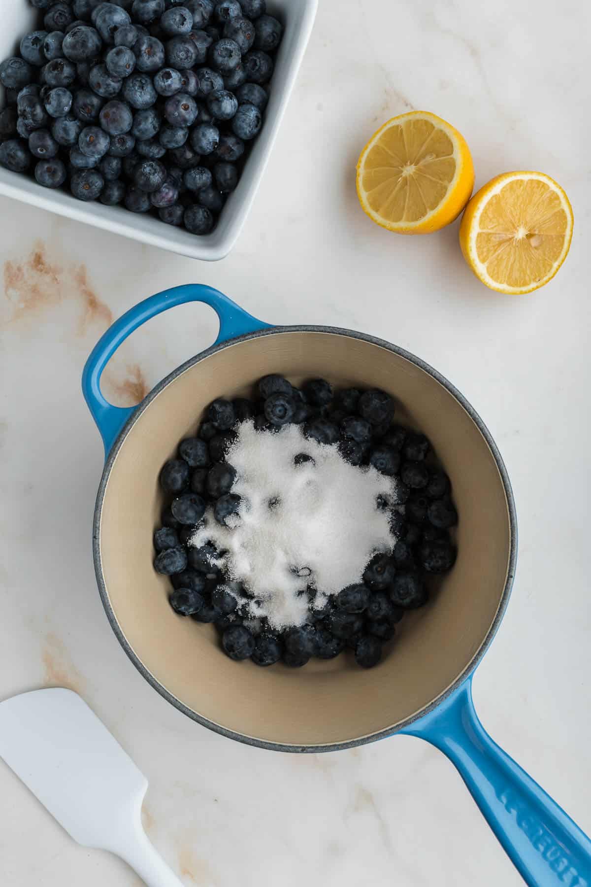 Ingredients for blueberry compote added to a saucepan.