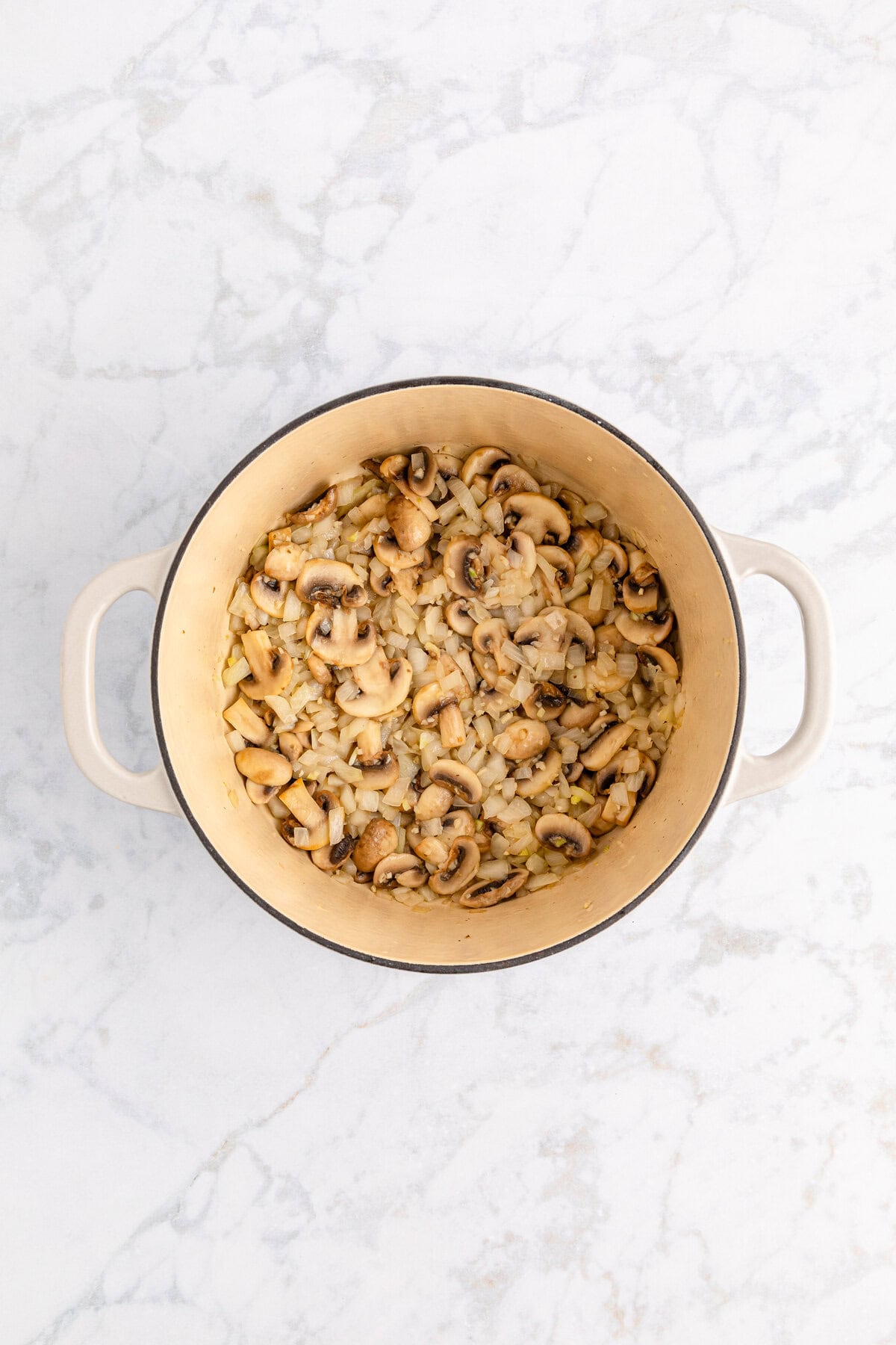 Sautéed mushrooms and onions in a large pot.