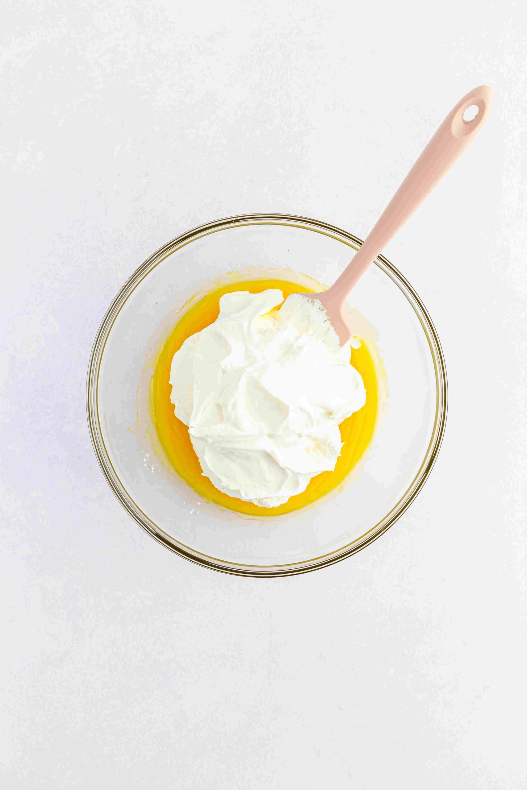 Adding cool whip to pineapple juice and jello pudding mix to make tropical fluff salad.